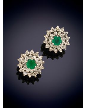 292-ELEGANTES PENDIENTES ESTILO ROSETÓN CON DOS ESMERALDAS CENTRALES Y DOS ORLAS DE BRILLANTES CADA UNA sobre una montura en oro blanco de 18K.