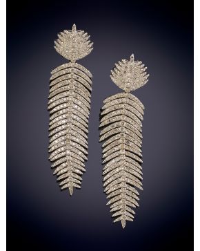 379-ELEGANTES PENDIENTES EN FORMA DE PLUMA DECORADOS POR BRILLANTES sobre una montura en oro de 18K y plata. 