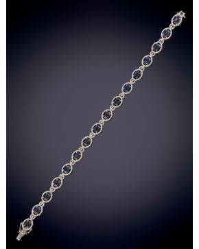 384-ELEGANTE PULSERA DE CENTROS DE ZAFIROS ORLADOS POR BRILLANTES sobre una montura en oro blanco de 18K. 