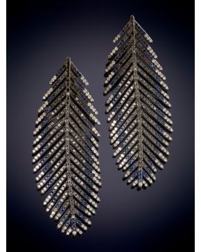 448-ELEGANTES PENDIENTES EN FORMA DE PLUMA DECORADOS POR BRILLANTES NEGROS Y BLANCOS, Y ZAFIROS sobre una montura en oro de 18K y plata. 