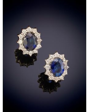 507-ELEGANTES PENDIENTES ESTILO ROSETÓN CON CENTROS DE ZAFIRO ORLADOS POR BRILLANTES sobre una montura en oro blanco de 18K.