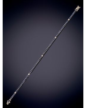 598-PULSERA RIVIERE DE ZAFIROS SALPICADOS POR BRILLANTES SOBRE UNA MONTURA DE ORO BLANCO DE 18K. Peso total de los zafiros: 4ct. aprox. Peso total de 