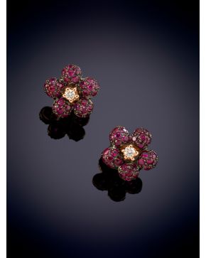 97-ELEGANTES PENDIENTES DE DISEÑO DE FLOR CON UN BRILLANTE, CUAJADOS EN RUBÍES sobre una montura en oro rosa de 18k. 