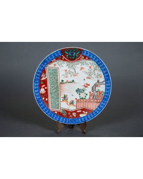 2254-Plato en porcelana Imari. Japón, c. 1900.  Decoración de paisaje y objetos simbólicos. Con sello.  Diámetro: 38,5 cm.