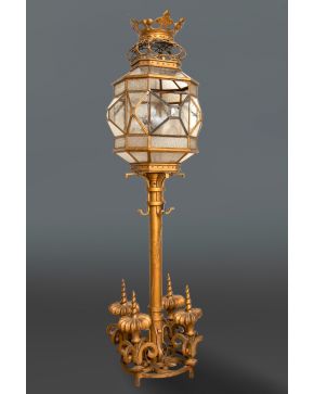 2141-Gran farol en metal dorado y cristal con pie decorado con pináculos y rematado en corona. Alguna falta. Altura: 165 cm.  PROCEDENCIA: Familia Mor