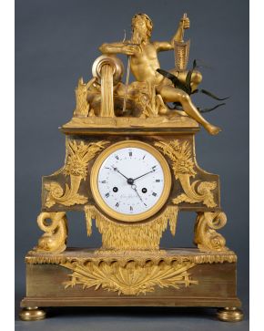 566-Reloj de sobremesa francés en bronce dorado al oro fino, Francia, Imperio, c. 1815. Remate de divinidad fluvial y esfera esmaltada, firmada: "Gast