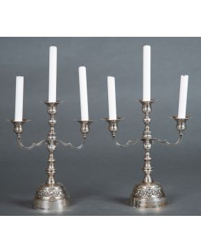 634-Pareja de candelabros de tres luces en plata mexicana punzonada con fuste moldurado, brazos con decoraciones apuntadas y base de flores cinceladas