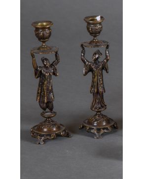 495-Pareja de candeleros en bronce pavonado, s. XIX, con fuste a modo de personajes orientales. Altura: 24 cm.