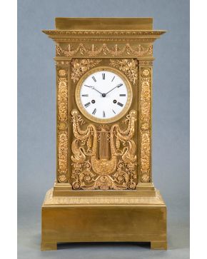 608-Reloj de sobremesa en bronce dorado, Francia, s. XIX.  Con decoración relevada de guirnaldas y flores sobre base rectangular decorada con palmetas