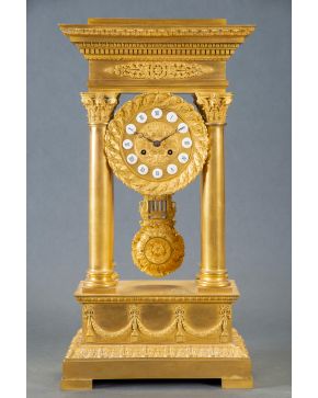 600-Reloj de pórtico en bronce dorado, Carlos X, Francia, C. 1830. Esfera flanqueada por columnas con numeración romana. Decoración de guirnaldas y el