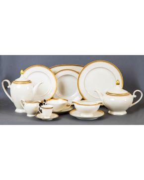 412-Vajilla en porcelana alemana con filos en dorado. Se compone de:  24 platos llanos, 12 platos hondos, 12 platos de postre, 12 tazas de consomé con