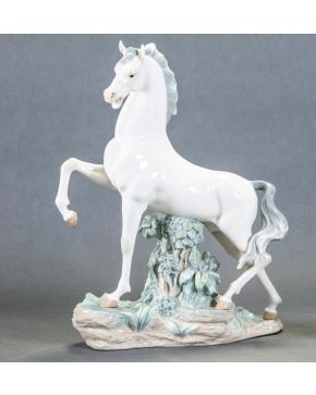 2232-LLADRÓ Escultura en porcelana esmaltada y vidriada de Lladró representando un caballo encabritado. Con marcas. Medidas: 44 x 34 cm. 