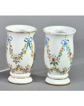 2084-Pareja de jarrones en porcelana esmaltada con decoración de guirnaldas. Algún piquete. Con marca Altura: 15 cm.