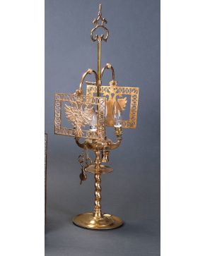 2200-Lámpara de aceite en metal dorado. Pie en columna salomónica. Decorada con escudos y águilas bicéfalas. Cuatro luces.