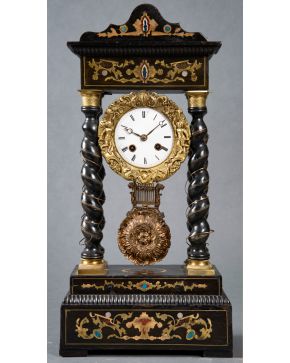 2073-Reloj de columnas Napoleón III, Francia s. XIX. En madera ebonizada con aplicaciones en bronce dorado. Esfera blanca con nume