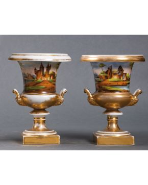 2082-Pareja de copas de estilo Medici en porcelana centroeuropea con escenas de paisajes y base y asas en dorado. Altura, 26 cm