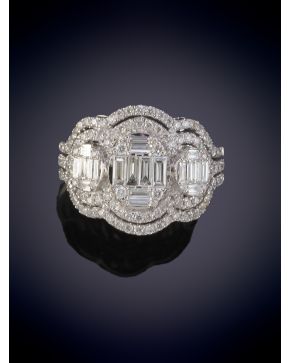 203-ELEGANTE SORTIJA CON FRENTE DECORADA POR DIAMANTES TALLA BAGUETTE ORLADO POR DOS HILERAS DE BRILLANTES. Montura en oro blanco de 18k. 