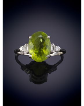 221-ELEGANTE SORTIJA CON BRILLANTES Y PERIDOTO CENTRAL DE 3.30 ct aprox. Montura en oro blanco de 18k.