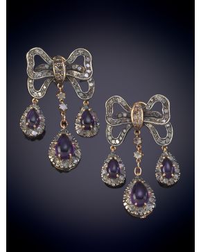 24-BELLOS PENDIENTES CON  FORMA DE LAZO DEL QUE PENDEN TRES AMATISTAS EN CABUJON DE 4,5 ct aprox. Montura en plata y oro de 14k. 