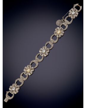 56-DELICADA PULSERA DE PEDIDA DE DIAMANTES CON FLORES CENTRALES DONDE DESTACA UN DIAMANTE CENTRAL DE MAYOR TAMAÑO Y PERLAS CULTIVADAS. Sobre