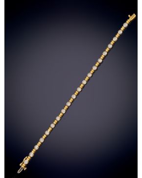 634-FINA PULSERA RIVIERE DE BRILLANTES CON UN PESO TOTAL DE 1,70CT. APROX. Sobre una montura chatón en oro amarillo de 18k. 