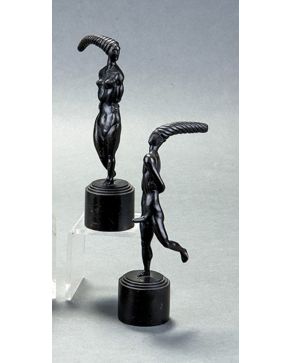 2377-ESCUELA EUROPEA, s.XX. Pareja de figuras danzantes de inspiración africana en bronce pavonado sobre pedestal con importante tocado. Alt