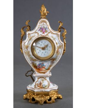 2256-Reloj de sobremesa francés, ff. s. XIX, en porcelana esmaltada, dorada y vidriada, con decoración de motivos florales, escena galante e