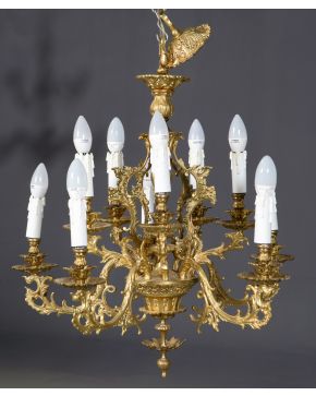 450-Elegante lámpara de techo en bronce dorado de diez luces. Decoración vegetal de rocallas y tornapuntas.  Altura: 76 cm. 