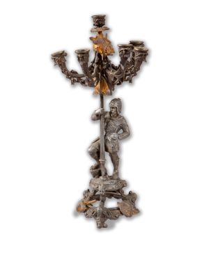 2168-Gran candelero de cinco luces en bronce pavonado. Vástago con figura de soldado. Decoración vegetal y detalles en d