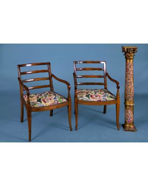 1225-Dos sillones en madera patinada c. 1900. con tapicería fija de petit-point. Respaldo calado y brazos curvos rematados en voluta.